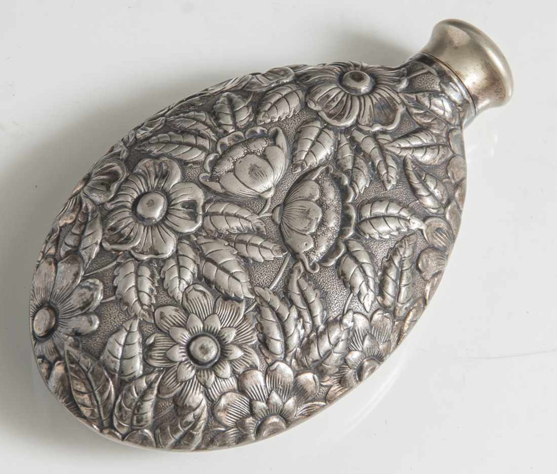 Flachmann, um 1900, Metall versilbert, ovale Form, die Schauseite mit reliefiertem Foraldekor.