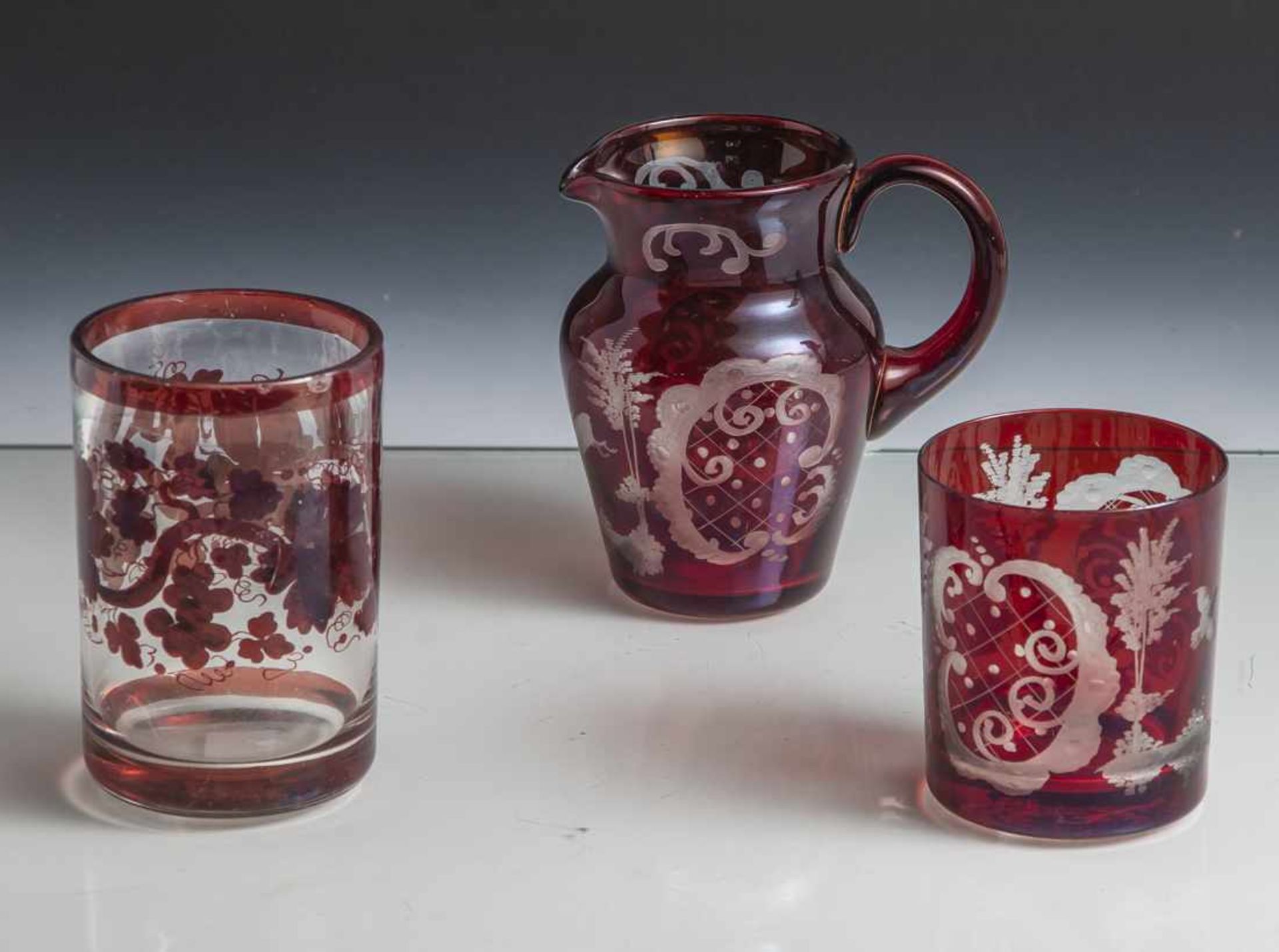 3 Teile Glas, Biedermeier, 2 Gläser und 1 kl. Krug, farbloses, mundgeblasenes Glas, rot lasiert, 2 x