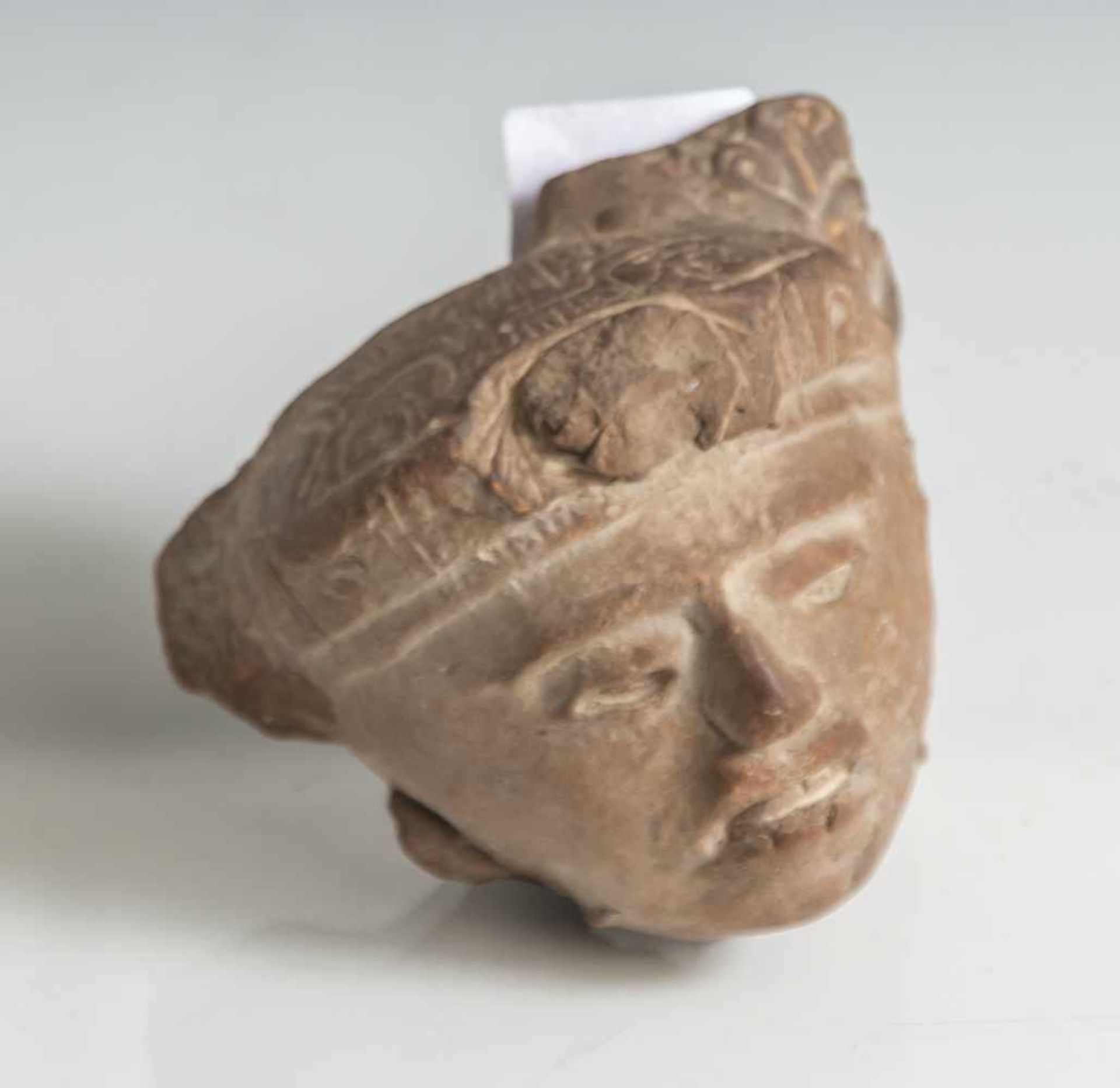 Tonfragment eines Kopfes, Maya-Kultur, wohl 250-600 n. Chri. H. ca. 8 cm, Br. ca. 9 cm.