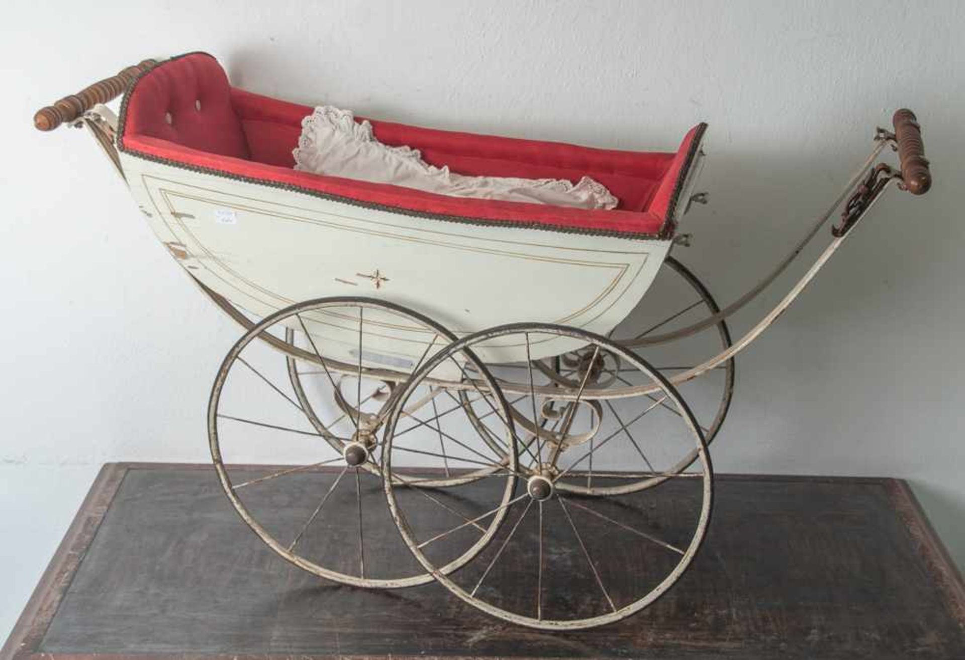 Puppenwagen, Ende 19. Jahrhundert, Holz/Metall, weiß lackiert, vierrädrig mit Speichen. Ohne