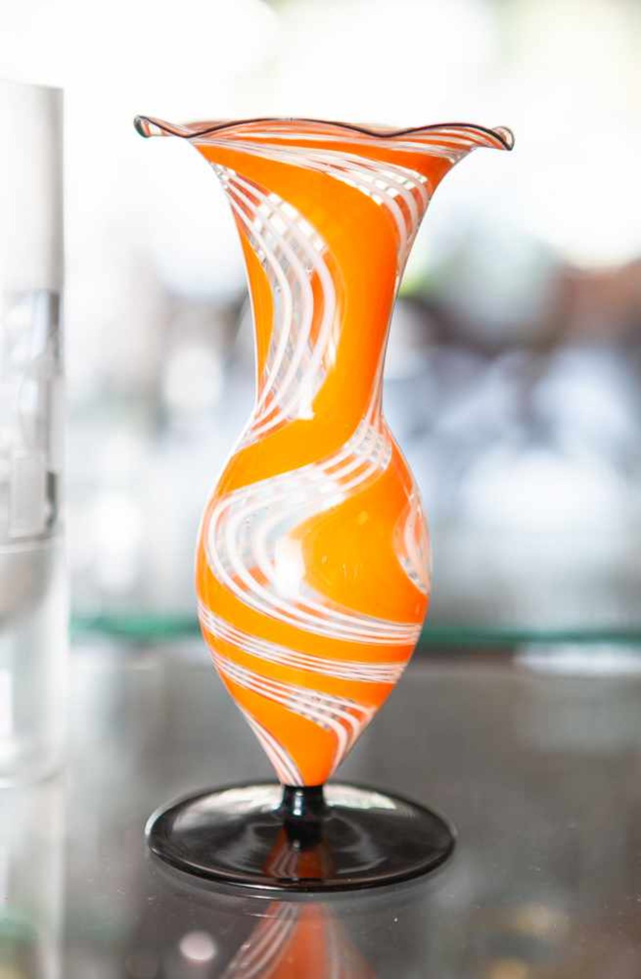 Kleine Vase, farbloses Glas, runder opak schwarzer Fuß, Korpus mit orange-weißerEinschmelzung,