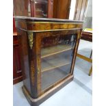 Single glazed door enclosing shelves applied with gilt brass ornamentation on a platform base