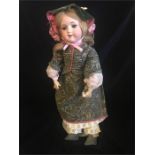 A German Armand Marseille doll with pink ribbon.