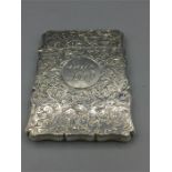 A silver card case with Chester hallmark and heavily engraved