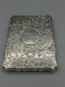 A silver card case with Chester hallmark and heavily engraved