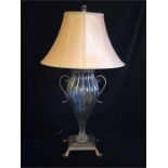 A wrought iron and glass lamp base and shade.