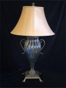A wrought iron and glass lamp base and shade.