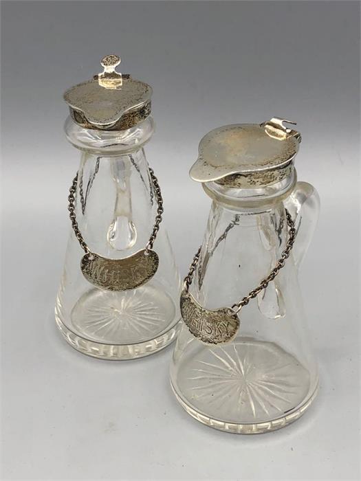 A pair of water jugs for whisky with hallmarked silver pourers and tags.