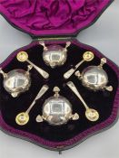 A boxed set of four Victorian silver salts with spoons, by Robert Harper and hallmarked London