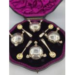 A boxed set of four Victorian silver salts with spoons, by Robert Harper and hallmarked London