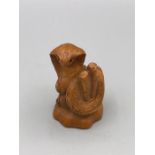 A carved wooden Japanese netsuke in the form of a snake signed to the base.