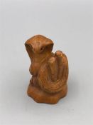 A carved wooden Japanese netsuke in the form of a snake signed to the base.