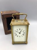 A brass carriage clock in a leather carry case