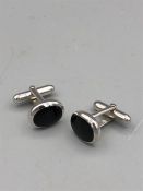 A pair of silver and onyx cufflinks