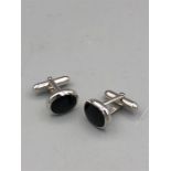 A pair of silver and onyx cufflinks