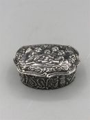 A silver lidded box with embossed decoration