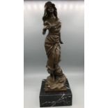A bronze statue of a lady on a marble plinth.