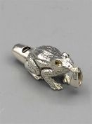 A silver whistle in the form of a frog with glass eyes