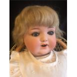 An Armand Marseile Bisque doll with socket head, blonde hair and blue eyes 48cm tall Made in Germany