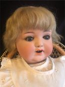 An Armand Marseile Bisque doll with socket head, blonde hair and blue eyes 48cm tall Made in Germany