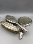 A hallmarked silver backed ladies dressing table set, comprising a hand mirror and two brushes.
