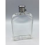 A glass flask with hallmarked silver top.