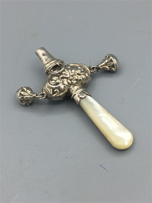 A mother of pear handled babies rattle in silver