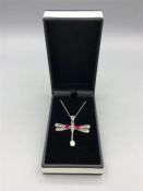 A silver ruby and opal dragon fly pendant necklace on silver chain