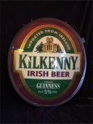 An illuminated Kilkenny beer sign with original swing bracket and taken out of box for photo.