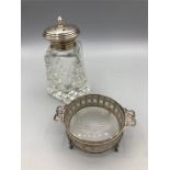 A silver topped sugar sifter and a glass dish in a silver mount.