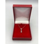 A 14ct white gold graduated three stone pendant necklace 40 points approx