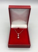 A 14ct white gold graduated three stone pendant necklace 40 points approx