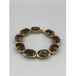 A 9ct yellow gold smokey quartz panelled bracelet