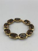 A 9ct yellow gold smokey quartz panelled bracelet