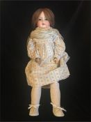 An Armand Marseille bisque doll with socket head, chestnut hair 65cm tall Germany 390 A.9.M