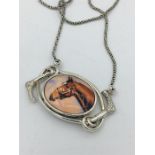 A silver and enamel necklace depicting a horse on silver chain