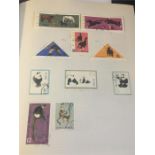 A Stamp Album with a variety of International stamps including flags and Pandas.