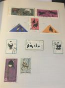 A Stamp Album with a variety of International stamps including flags and Pandas.