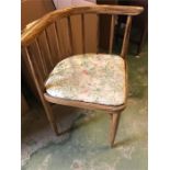 A corner chair with pillar back and floral seat pad