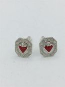 A pair of silver cufflinks set with enamel hearts