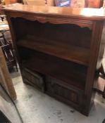 An oak bookcase with cupboards under