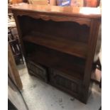 An oak bookcase with cupboards under