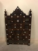 A Persian carved screen with mother of pearl inlay.