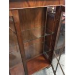 A display cabinet with glass shelves and backlighting.