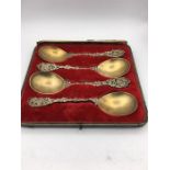 A boxed set of four ornate and gilded spoons by MW & Co 1892.