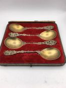 A boxed set of four ornate and gilded spoons by MW & Co 1892.