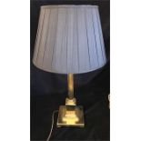 A brass column lamp base with black shade.