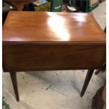 A mahogany drop leaf table on castors.