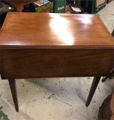 A mahogany drop leaf table on castors.