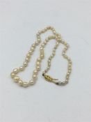 A cultured row of graduated pearls on 18ct yellow gold diamond set clasp